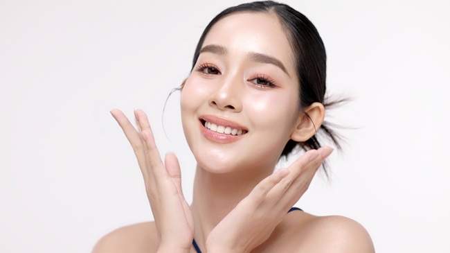 femeie coreeană care aplică un produs de îngrijire inspirat din K-Beauty